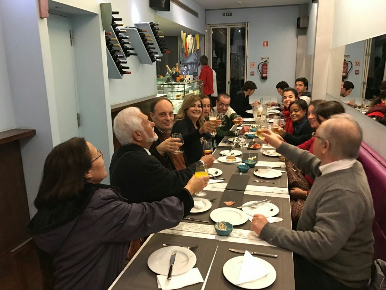 Amigos e familiares brindando em um restaurante a conquista de Dolores